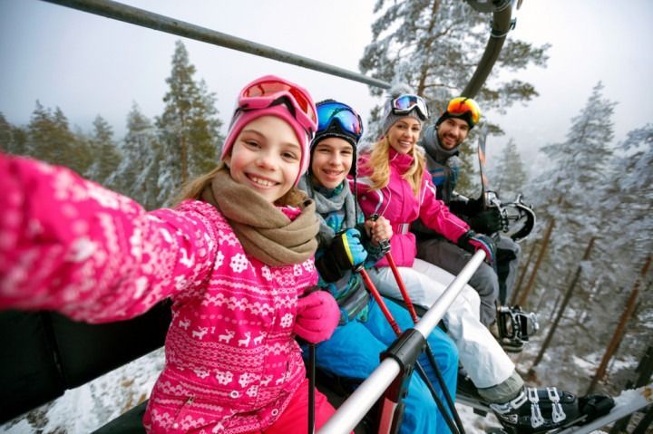 A family is taking a selfie on a ski lift.