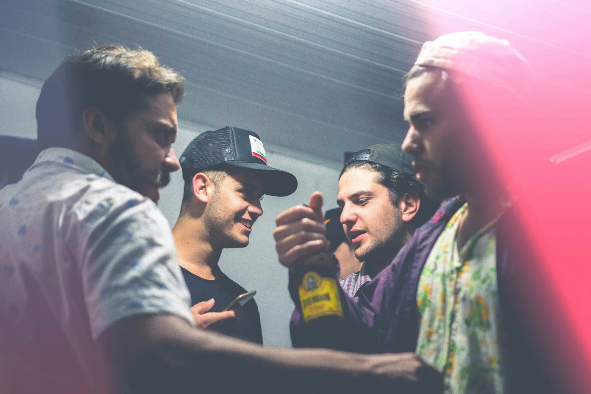 Men enjoying a bachelor party, smiling, enjoying alcoholic drinks.