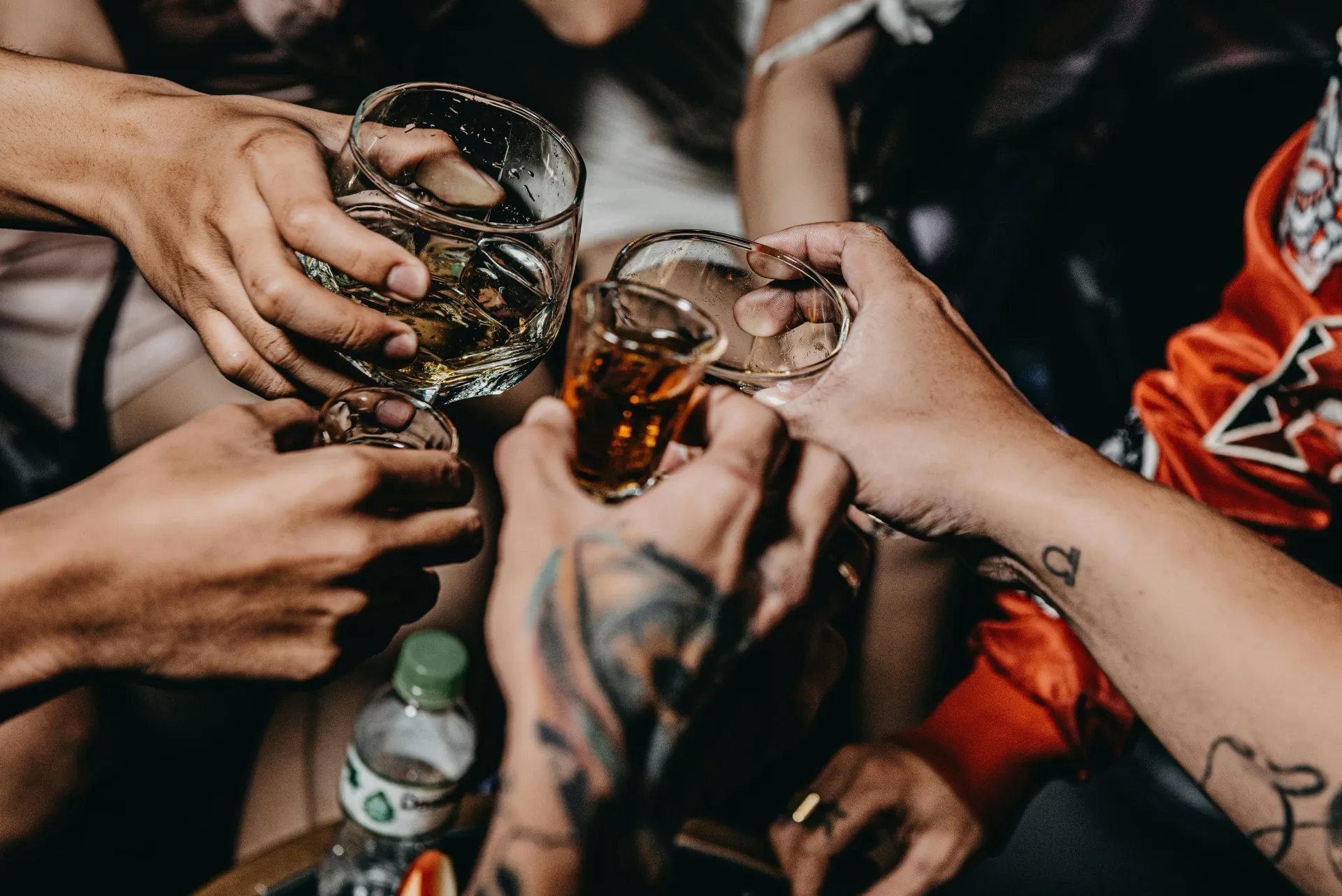 People toasting with glasses of alcohol at a bachelor party.