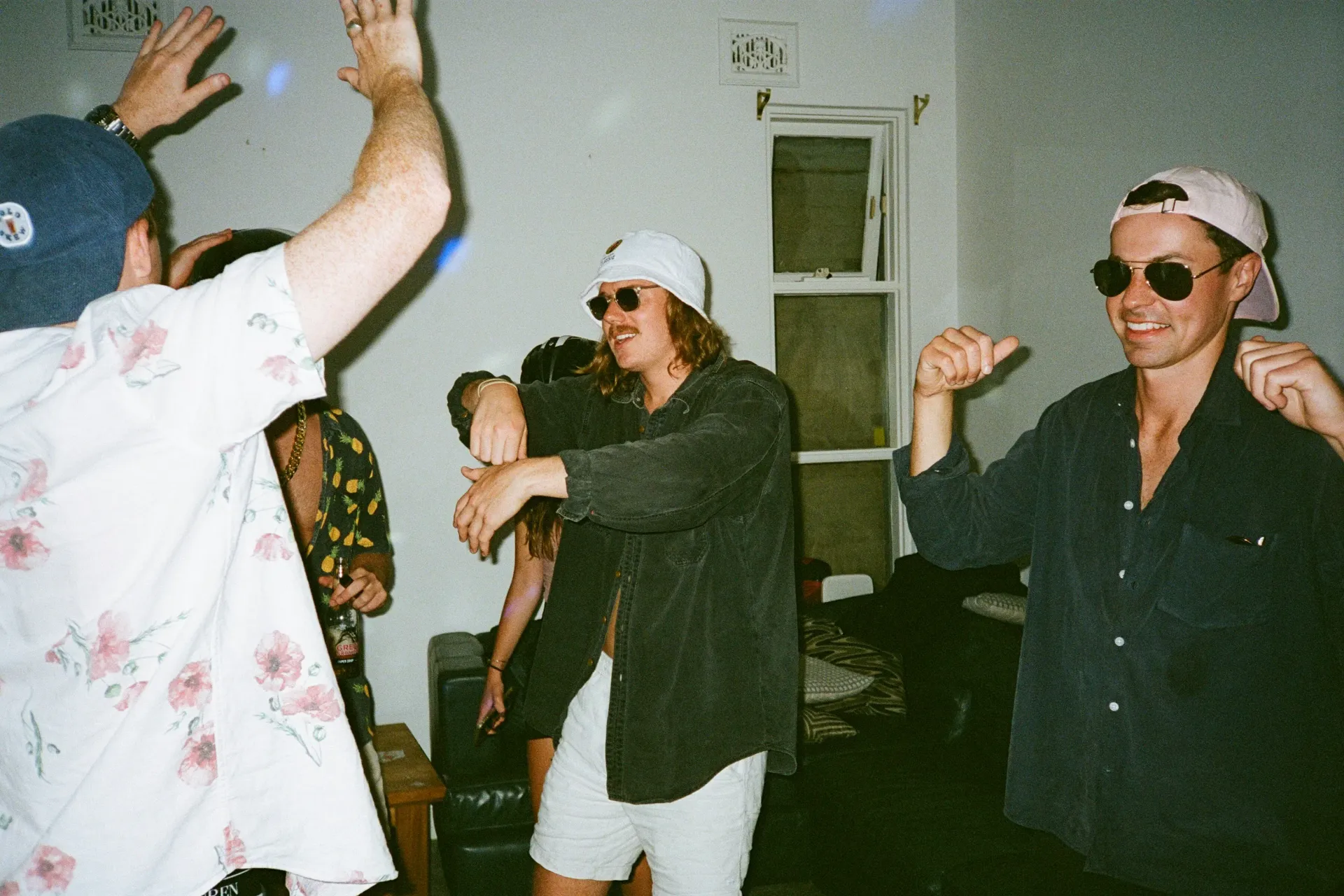 Group of men dancing at a house party.