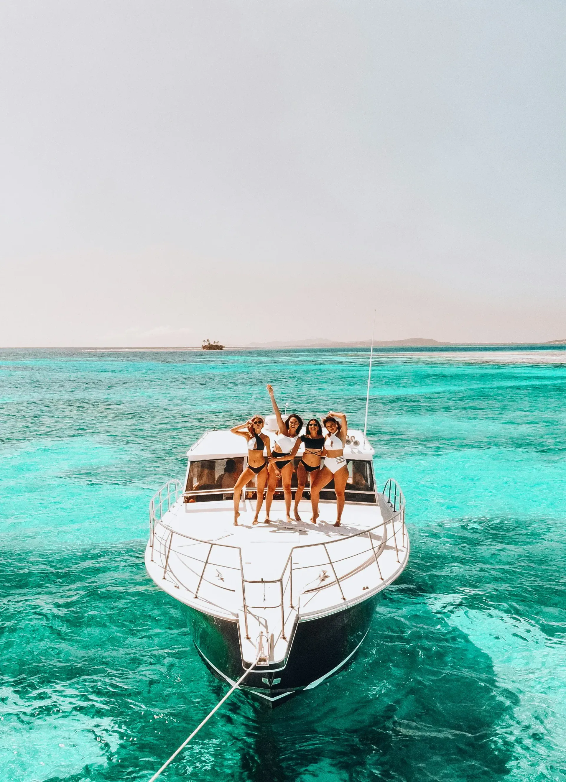 Group of women in swimsuits posing on a yacht.