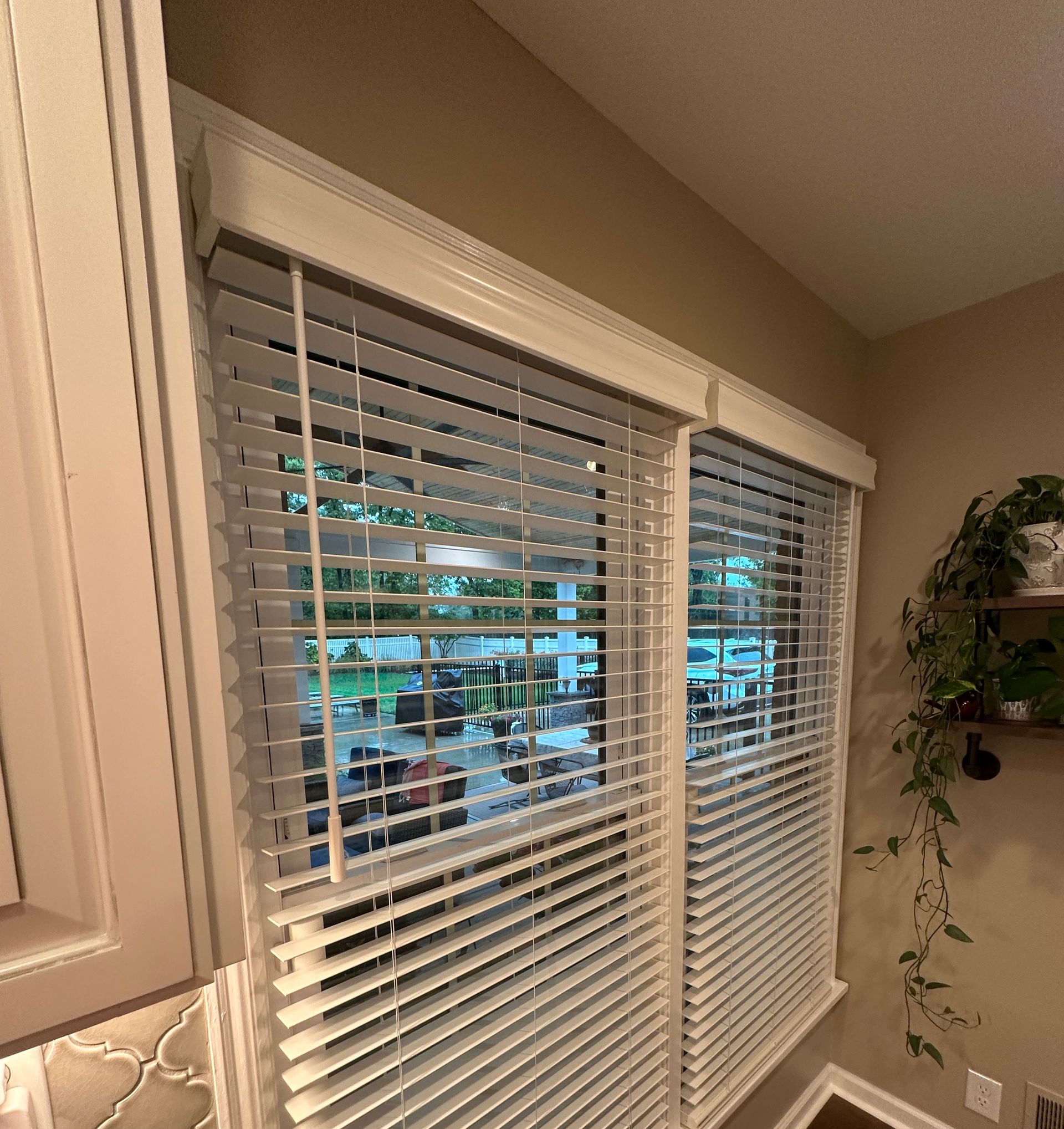 Bedroom with colorful accents with white faux wood blinds on two windows - window fashions on wheels, kentucky.