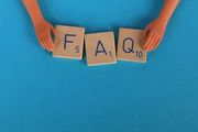 Two hands hold Scrabble-style tiles spelling