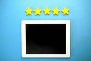 A tablet with a black screen rests on a blue background below a horizontal row of five yellow stars.