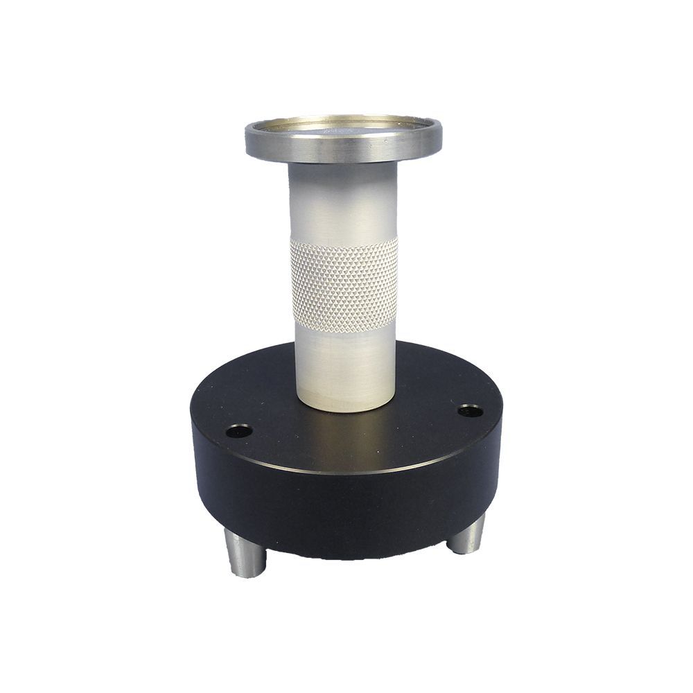 A metal object is sitting on top of a black base on a white background.