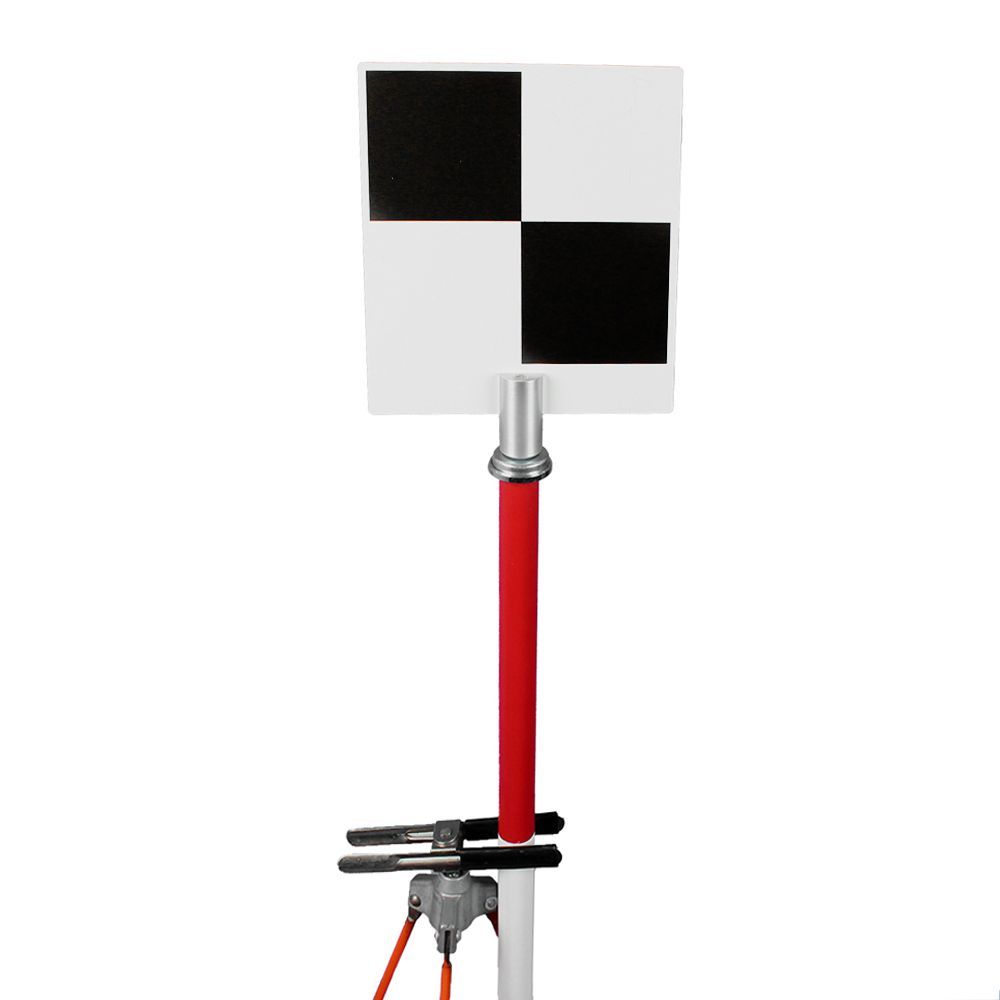 A black and white checkered sign is sitting on top of a red pole.