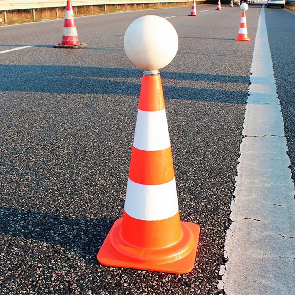 Orange and white traffic cones with a white ball on top