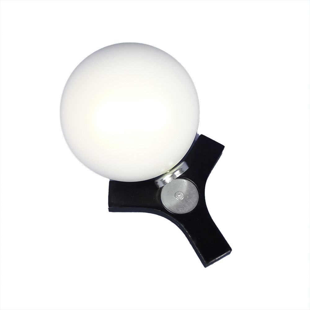 A black lamp with a white ball on top of it