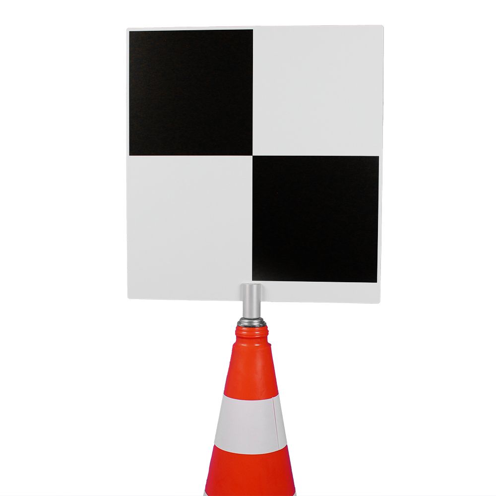 A black and white checkered sign is sitting on top of an orange and white traffic cone.