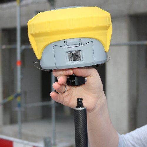 A person is holding a yellow and gray device in their hand