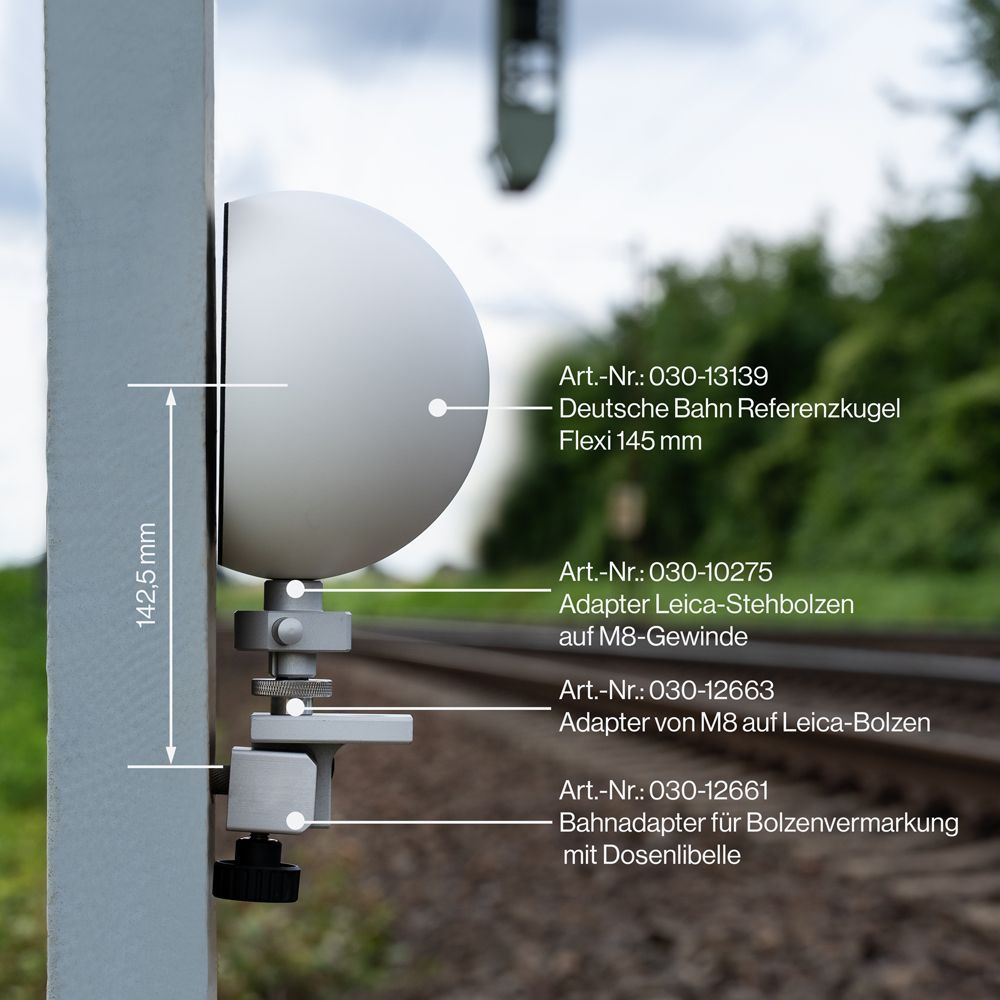 A yellow pole with a white ball attached to it is next to a train track.