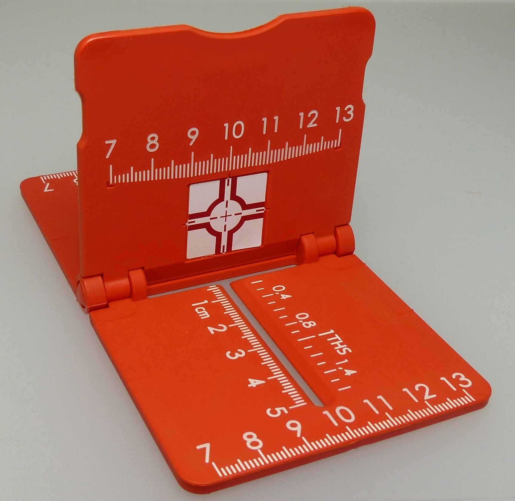 A red ruler with the numbers 7 8 9 10 11 12 13 on it