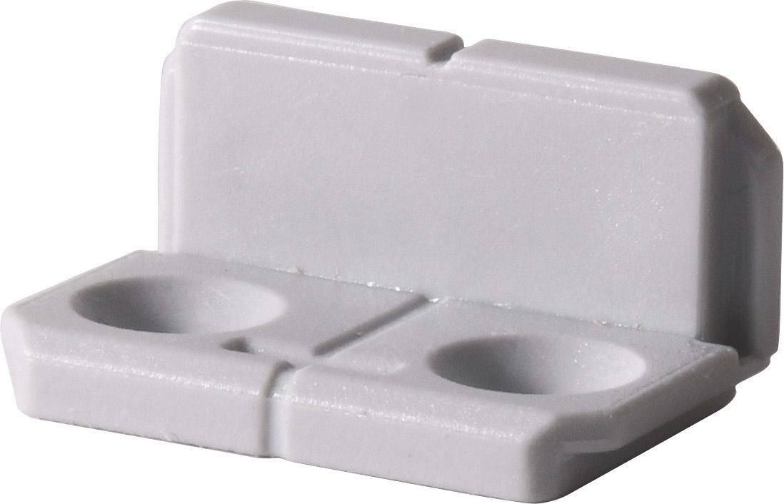 A white plastic block with two holes in it on a white background.