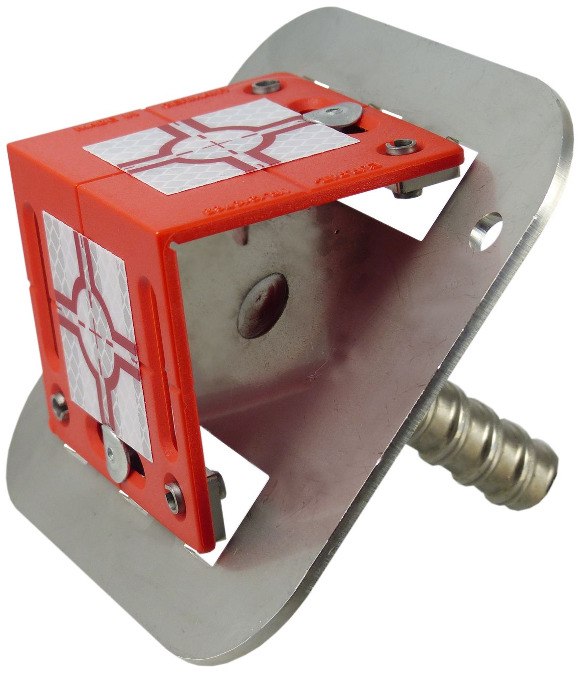 A red cube with a white cross on it sits on a metal plate