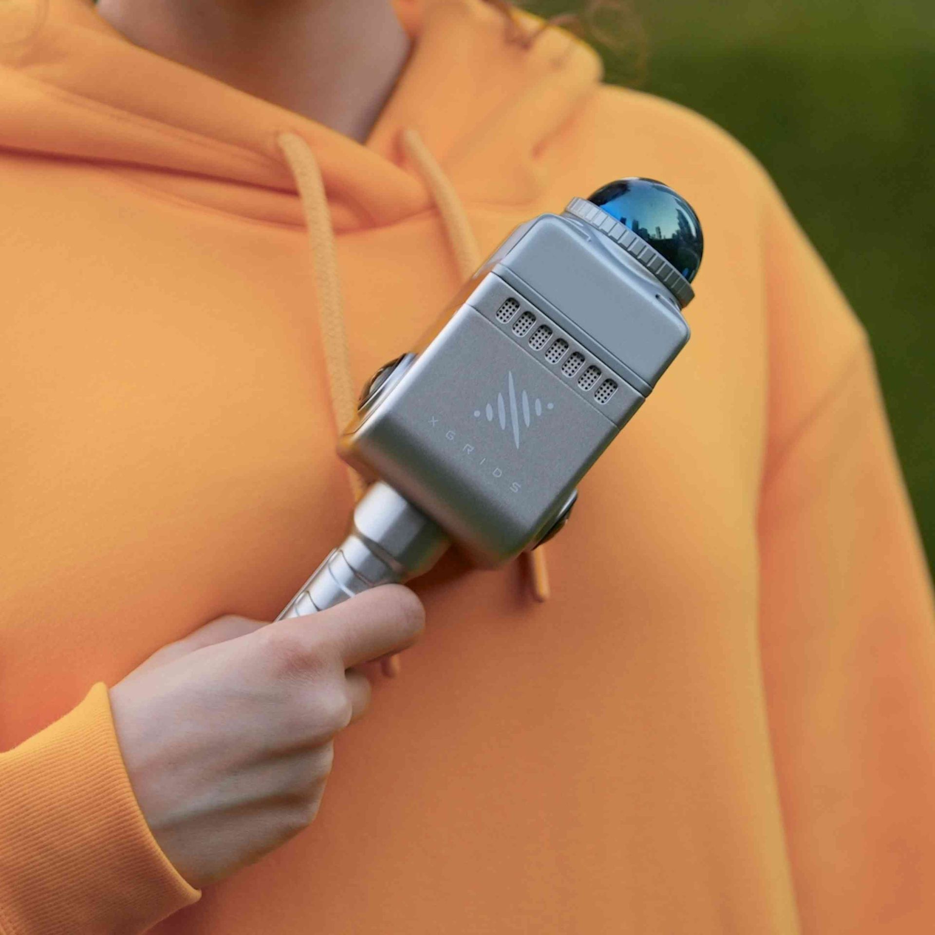 A person in an orange hoodie is holding a microphone