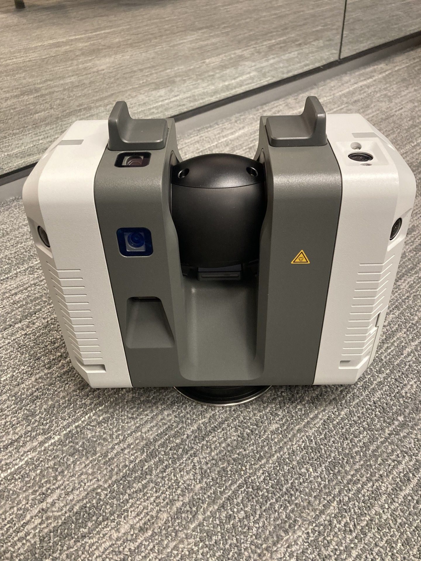 A white and gray machine is sitting on a carpet.