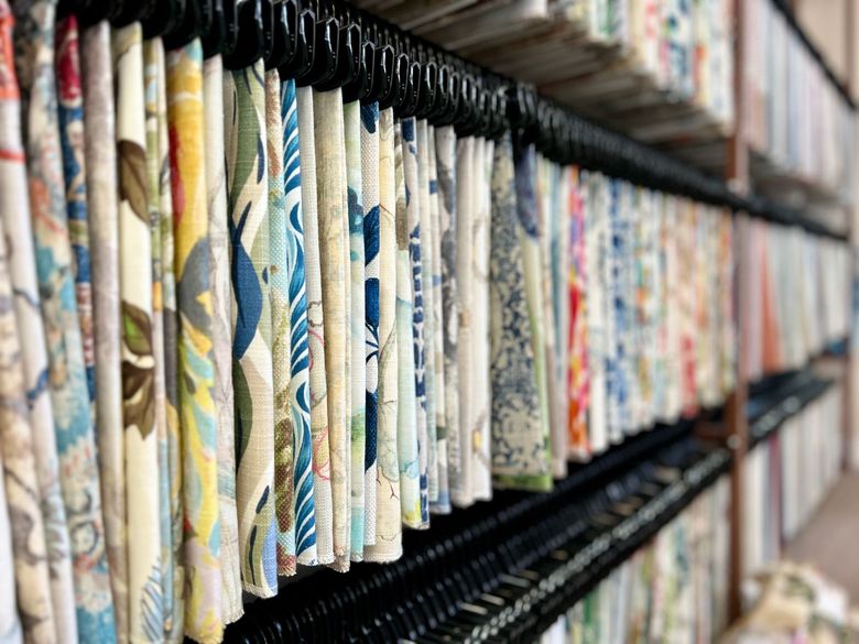 A row of curtains hanging on a shelf in a store.
