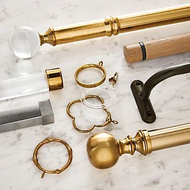 A table topped with a variety of curtain poles and rings
