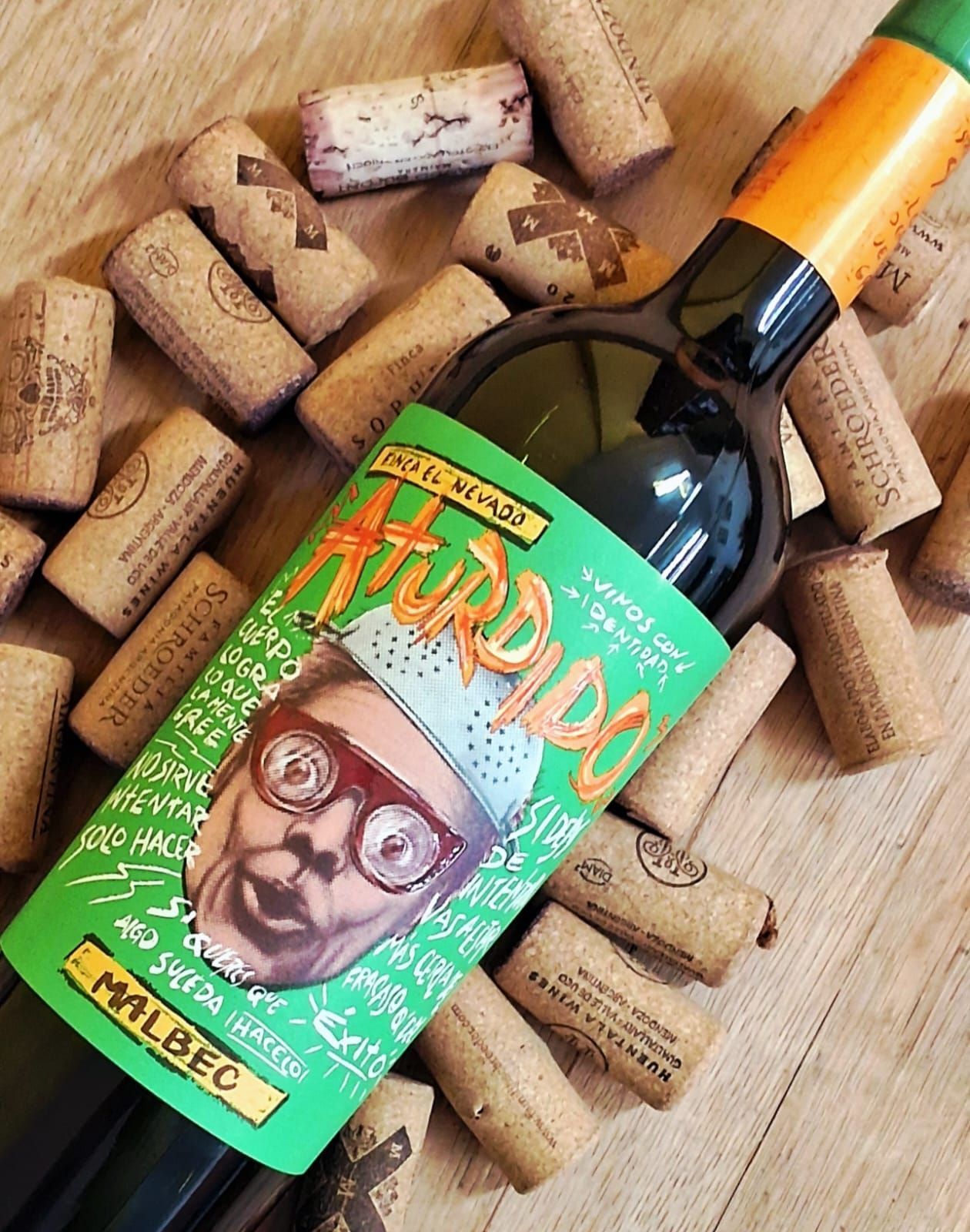 Una botella de vino Malbec con una etiqueta ilustrada de color verde brillante