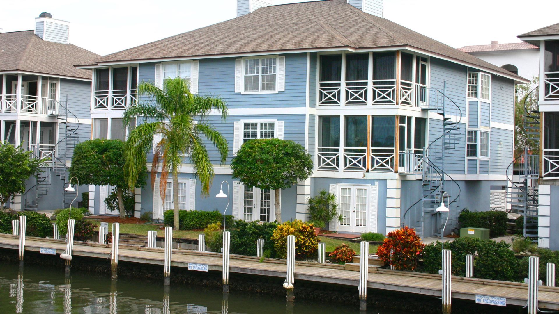 a blue house with a staircase leading up to the second floor