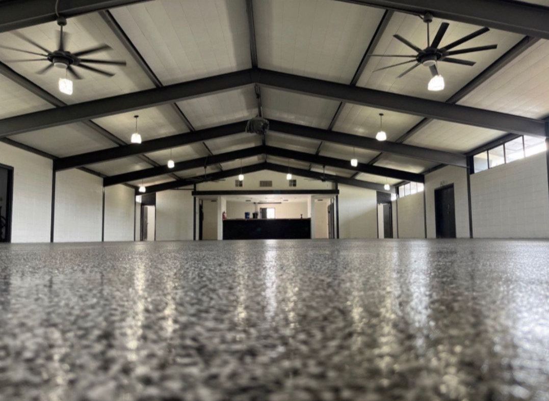 view of a residential garage and driveway with concrete floor coating