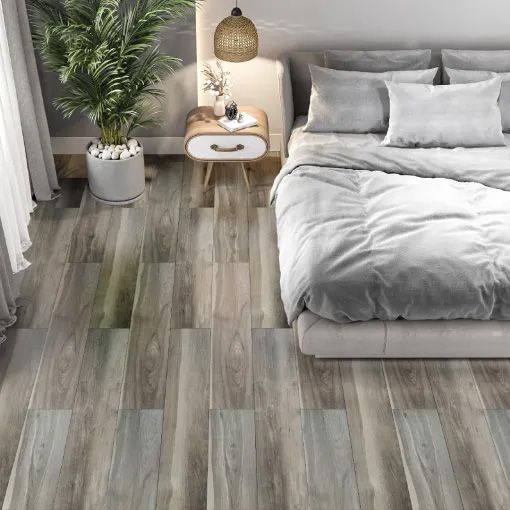 A bedroom with a bed and a plant on the floor.