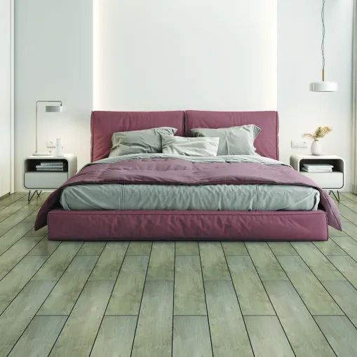 A bedroom with a purple bed and a wooden floor.