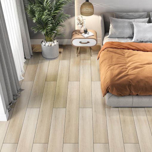 A bedroom with a bed , nightstand , and plant on the floor.