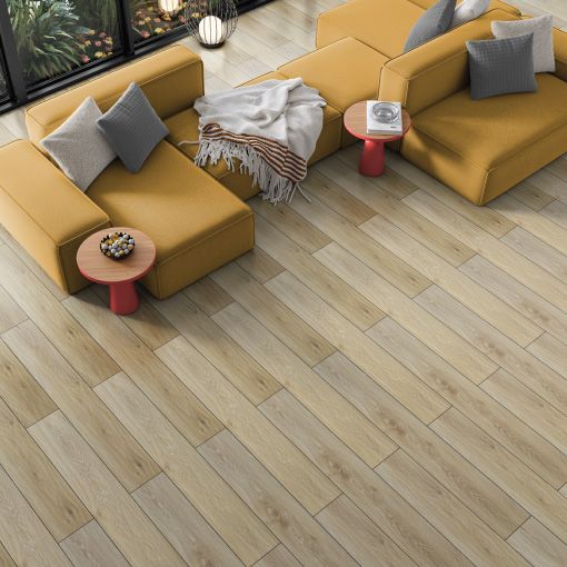 A living room with a yellow couch and two chairs on a wooden floor.