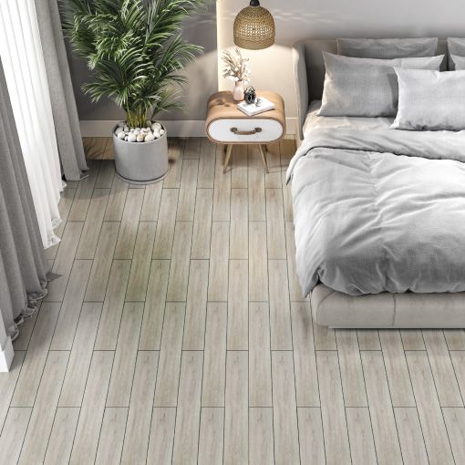 A bedroom with a bed , nightstand , and plant on the floor.