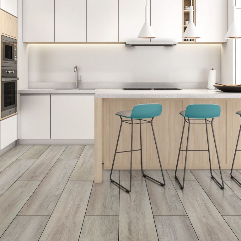 A kitchen with white cabinets and wooden floors