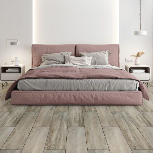 A bedroom with a pink bed and a wooden floor.