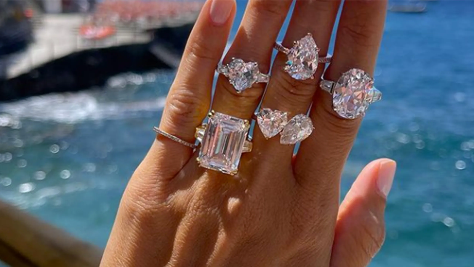 A woman is holding a bunch of rings on her finger.