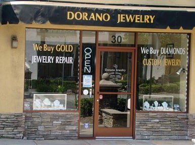 Dorano Jewelry storefront, tan exterior with brick facade, gold lettering,