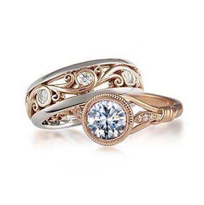 Two-tone wedding rings: engagement ring with diamond, and matching band with scrollwork and diamonds.