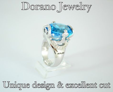 Blue gemstone ring with diamond accents on a clear display stand. 