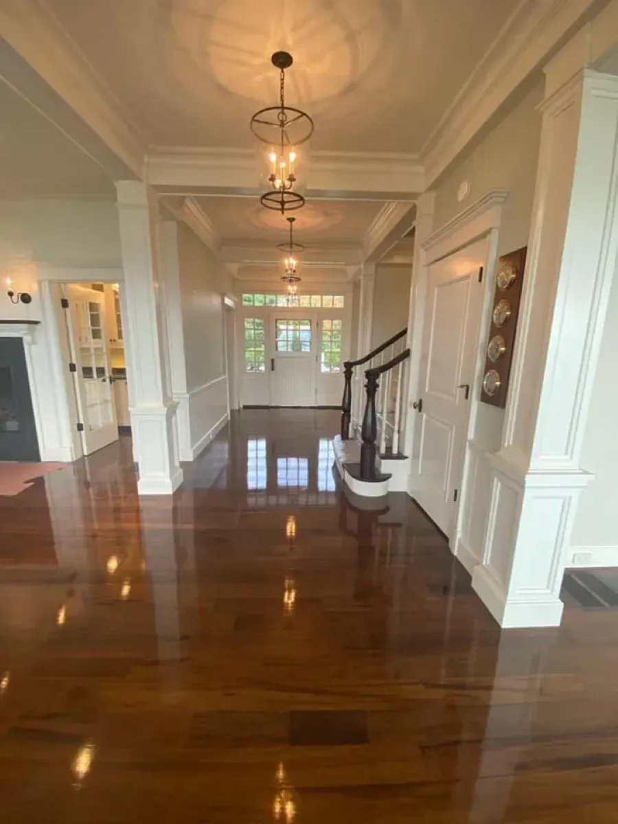 A hallway with hardwood floors and stairs in a house