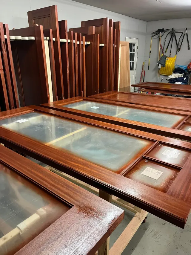 A bunch of wooden doors are sitting on top of each other in a room.
