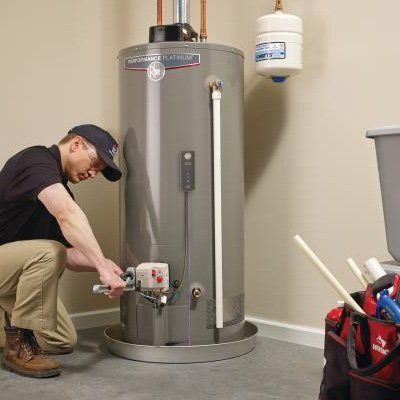 Man Fixing Water Heater — Overland Park, KS — AJ Plumbing Electric LLC Man Fixing Water Heater — Overland Park, KS — AJ Plumbing Electric LLC