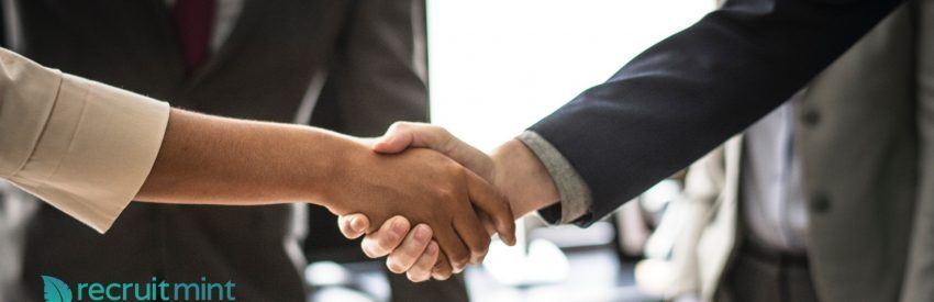 Two people in business attire shaking hands, symbolizing a professional agreement