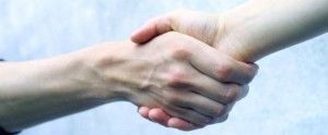 Two hands shaking in a close-up, symbolizing agreement or greeting