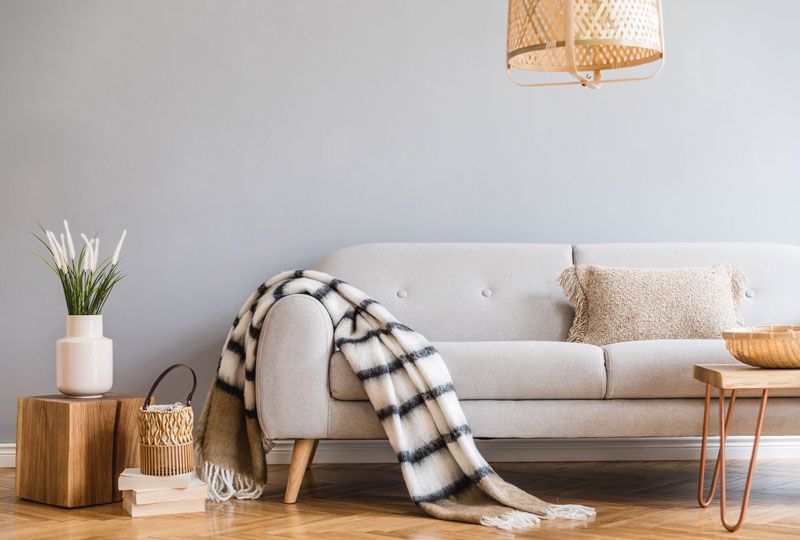 There is a couch with a blanket on it in the living room.