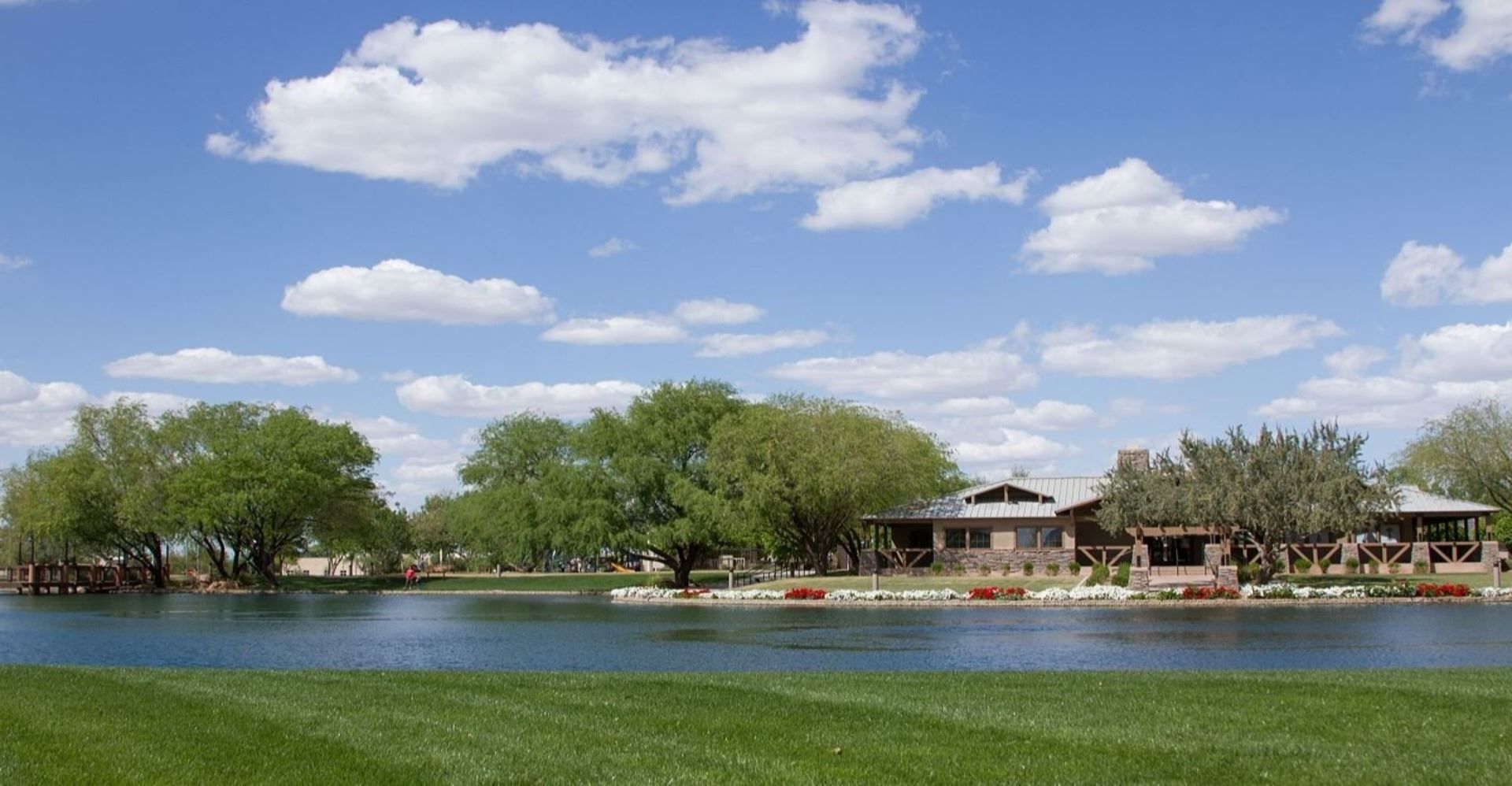 A house sits on the shore of a lake surrounded by trees.