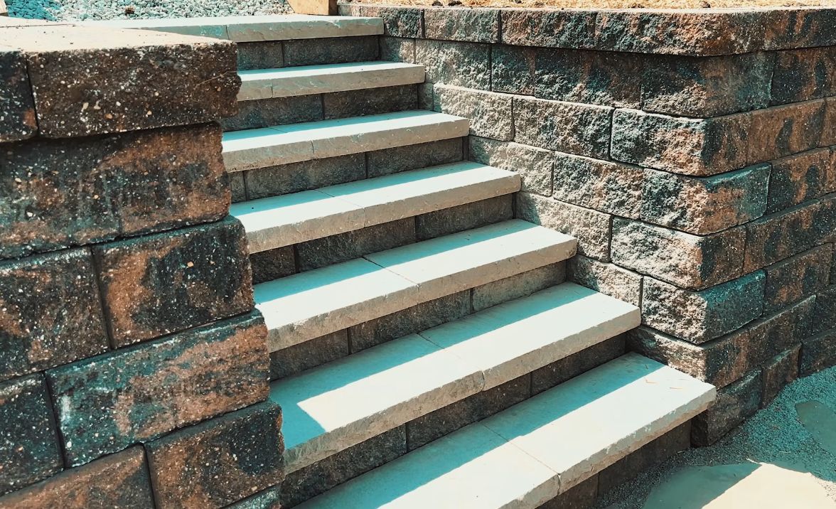 Stone steps between rough brick walls, with white-edged treads and turquoise floor accents.