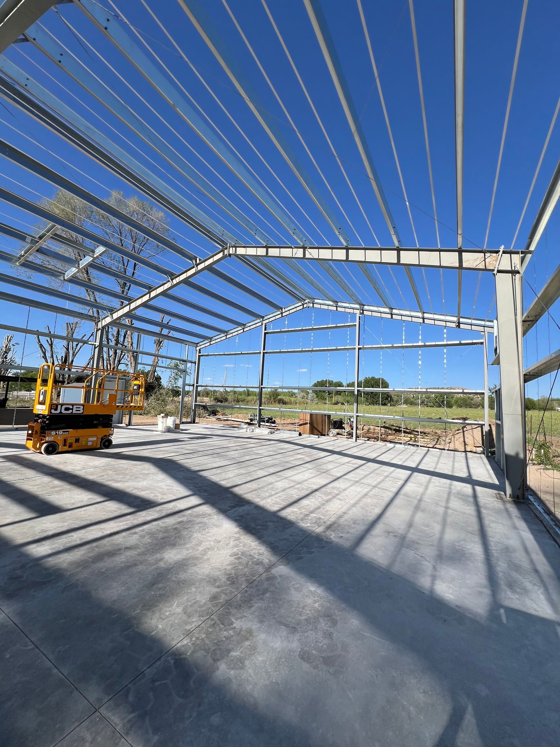 A large wooden house is being built in a field