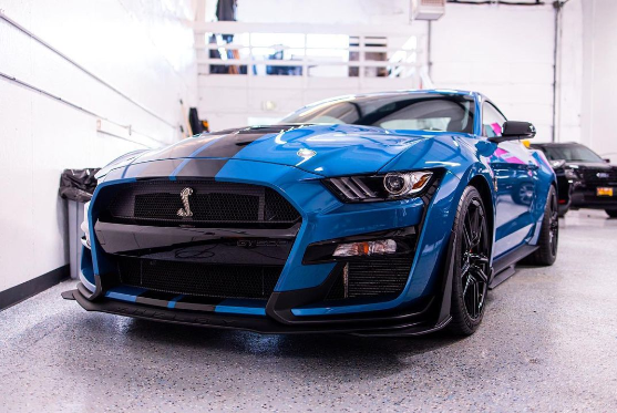Blue and black Ford Shelby Mustang in a garage.