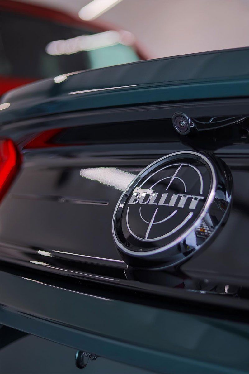 Close-up of a dark green Ford Mustang Bullitt emblem on the trunk.