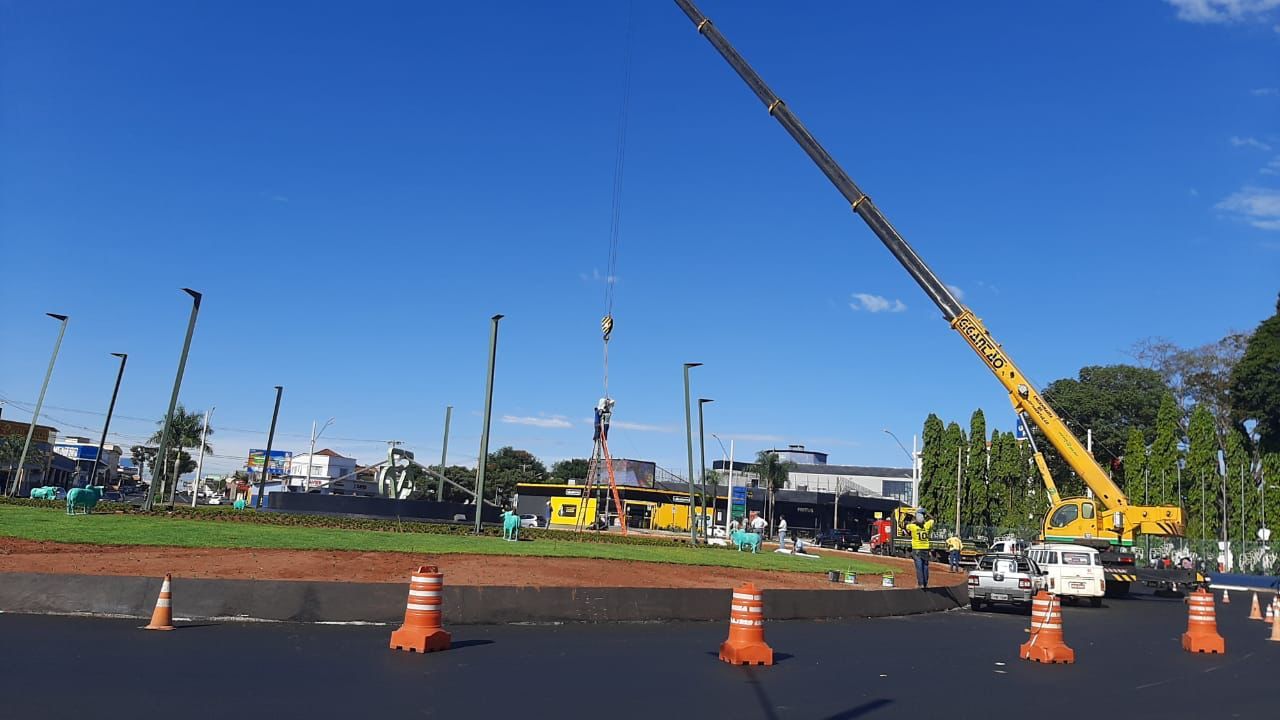 Um grande guindaste amarelo está sentado na beira de uma estrada.