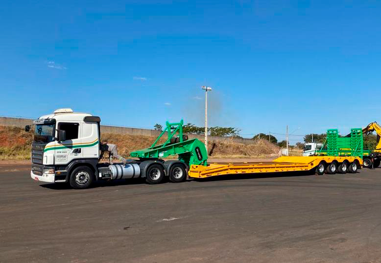Um caminhão semirreboque está descendo uma estrada com um trailer acoplado a ele.
