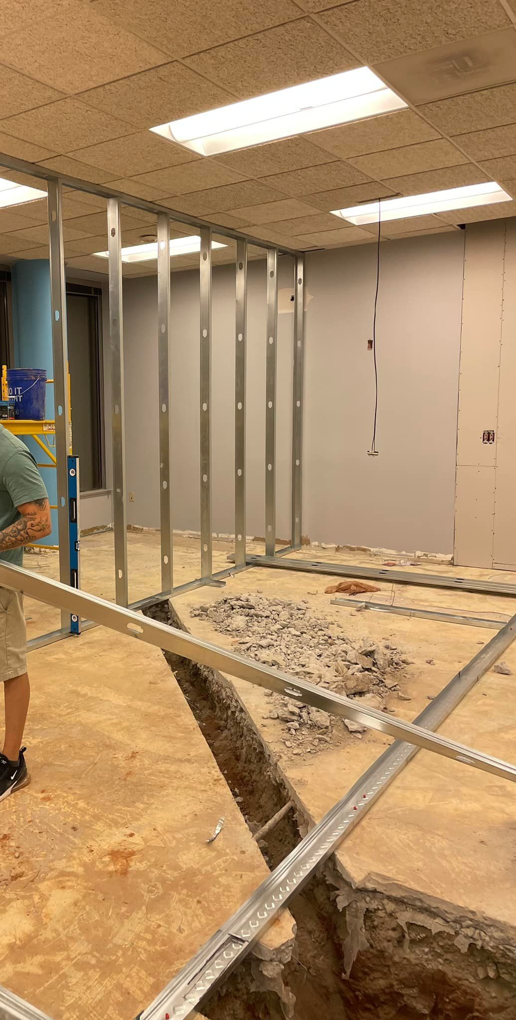 A man is standing in a room with a hole in the floor.